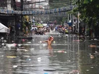 连续数个台风造成持续降雨，使奎松市多条街道被洪水淹没，有些居民声称看到...